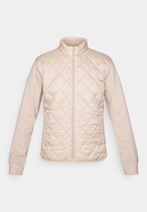 Giacca beige con design a diamante trapuntato sulla parte superiore e maniche lisce. Presenta un colletto alto e una chiusura con zip a tutta lunghezza.
