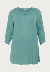 Blusa turchese leggera con maniche a tre quarti, scollatura rotonda e dettagli plissettati. Presenta un'apertura a chiave frontale e una texture morbida.