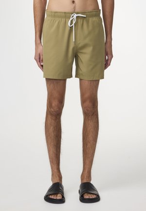 Olivgröna badshorts med resårmidja, vit dragsko och en enkel design. I kombination med svarta flip-flops.