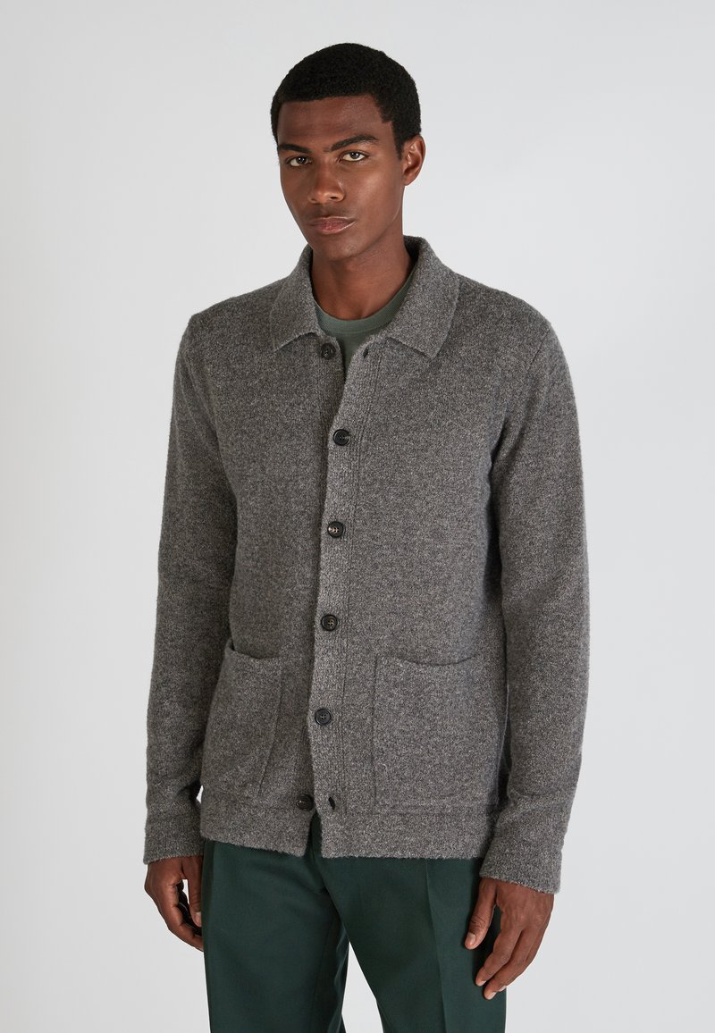 Grau gestrickte Wolle-Kardigan mit einer gepunkteten Vorderseite, Kragen und zwei vorderen Taschen. Texturiertes Material und gerippte Bündchen sorgen für visuelles Interesse.