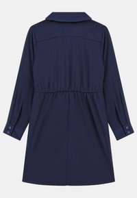 Granatowa sukienka z długimi rękawami, kołnierzykiem, marszczoną talią i guzikami na mankietach. Gładka tekstura i jednolity kolor.
