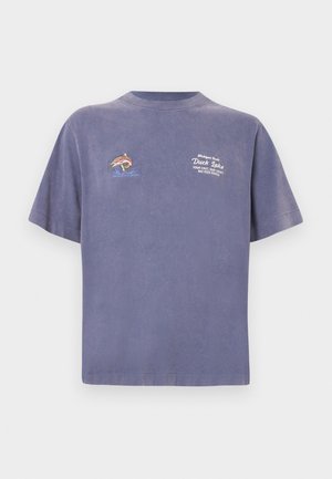 Lila pamut póló, amelyen halhímzés és szöveg található az elején. Rövid ujjú, kényelmes szabású. Simább tapintású anyag.