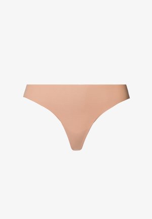 Hladké nahé tanga spodní prádlo vyrobené z měkké tkaniny, s minimalistickým designem a hladkou strukturou bez viditelných švů nebo vzorů.