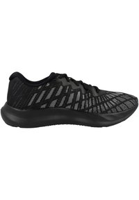 Chaussure de sport noire avec une tige en mesh texturé, présentant un design à motifs. Semelle en caoutchouc à profil bas et système de laçage.