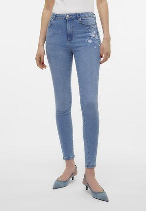 Skinny blue jeans made of denim with an intricate floral embroidery design on the left thigh and a mid-rise waistband.