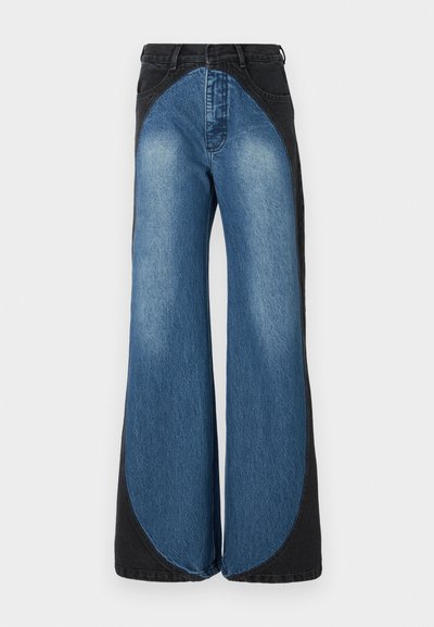 Wide-leg jeans featuring a high waist, made from a blend of light and dark denim. Distinctive curved side panels create a bold design.