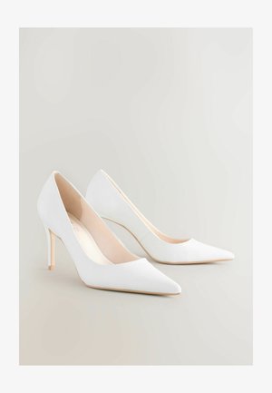 Baltos aukštakulnės bateliai su smailiais pirštais ir glotniam matinio paviršiaus. Pasižymi lieknu kulnu ir nuogo atspalvio vidumi. Minimalistinis dizainas.