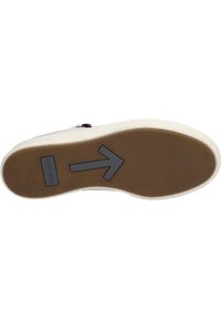 Shoe sole features a textured brown rubber surface, white edge, and a black arrow design pointing right. Includes a label with text.