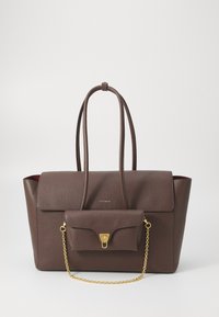 Sac en cuir marron avec deux longues anses, une surface texturée, et une petite poche avant avec une bandoulière en chaîne dorée et une fermeture à clip.