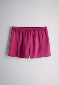 Plain bright pink elastic waistband shorts with a smooth fabric texture, displayed against a neutral gray background.