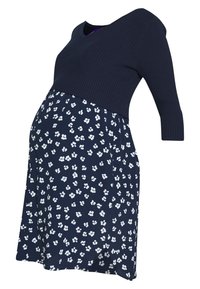 Robe de maternité bleu marine avec haut à manches trois-quarts côtelées et jupe à motif floral blanc sur fond bleu marine.
