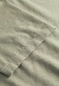 Ανοιχτό γκρι ύφασμα με μαλακή υφή και ελαφρύ γυάλισμα. Διαθέτει καλοραμμένο τελείωμα και διακριτικές παραλλαγές στο χρώμα σε όλη την επιφάνεια.
