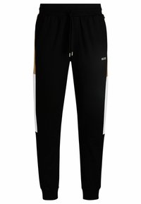 Black sweatpants featuring white and tan side panels, drawstring waist, and ribbed cuffs. The brand logo "BOSS" is displayed on the front.
