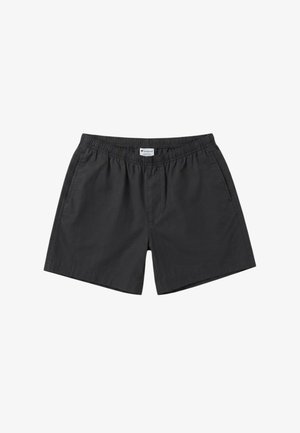 Pantaloncini neri con vita elastica, tasche laterali e una piccola etichetta bianca del marchio al centro della vita.