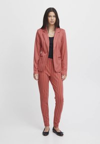 Red pinstriped blazer and trousers set made of smooth fabric. Features a tailored design with a single-button closure and slim fit.