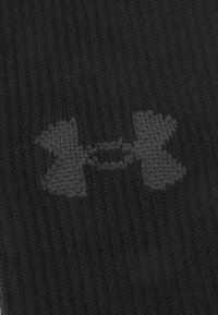 Schwarze gestrickte Socke mit einem dezenten grauen Under Armour Logo-Muster. Strukturiert Oberfläche mit Rippendesign für Komfort und Passform.
