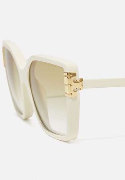 Ochelari de soare supradimensionați, de culoare albă, cu finisaj mat, accente din metal aurit și o formă pătrată. Lentilele cu nuanță treptată adaugă un detaliu elegant.