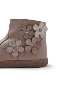Stivaletto in pelle marrone con applicazioni floreali. Caratterizzato da una superficie testurizzata, accenti glitter e pietre decorative sui fiori. Suola in gomma morbida.