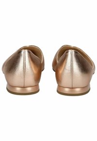 Metaliczne różowe złote baleriny o gładkiej powierzchni, zaokrąglonym czubku i niskim obcasie. Szczegóły przeszycia biegną wzdłuż szwu obcasu.