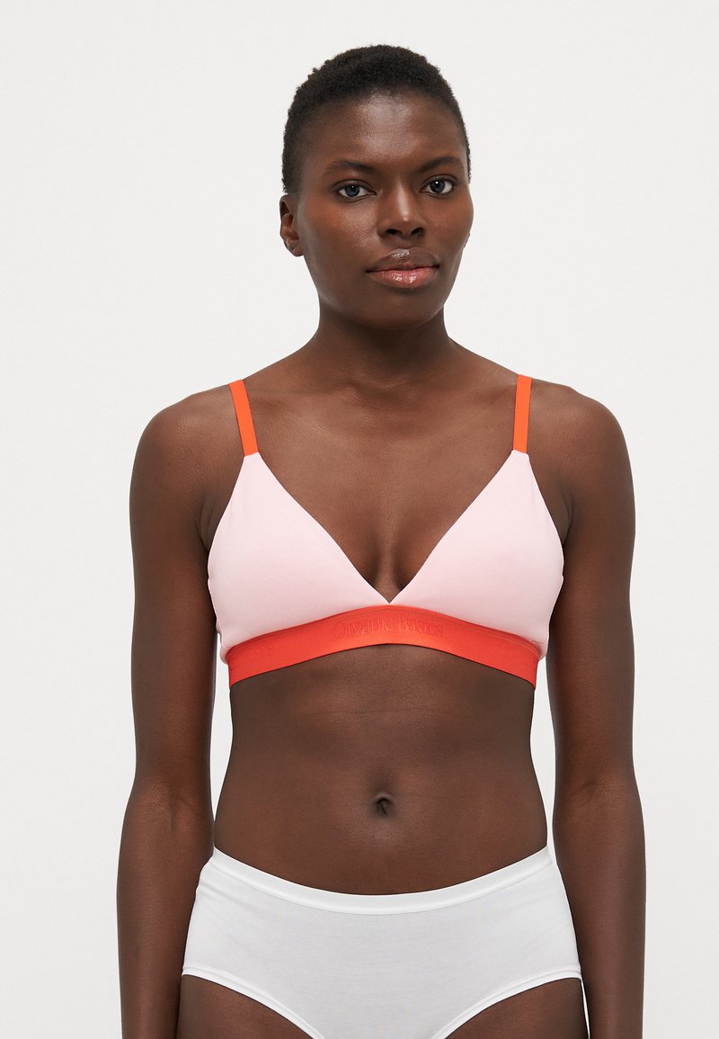 Bralette rose avec un design triangulaire, des bretelles orange et une bande orange avec du texte en relief. Tissu doux avec un minimum de détails.
