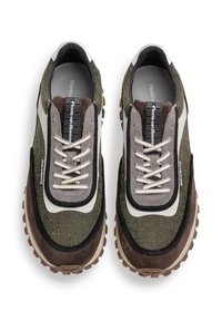 Sneaker in suede verde e marrone con tessuto testurizzato, accenti bianchi a contrasto, lacci rotondi e suole in gomma spessa.