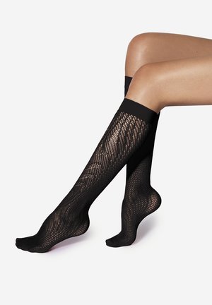 Calze nere fino al ginocchio caratterizzate da un design a rete, texture liscia e una fascia solida nella parte superiore; progettate per una vestibilità aderente.