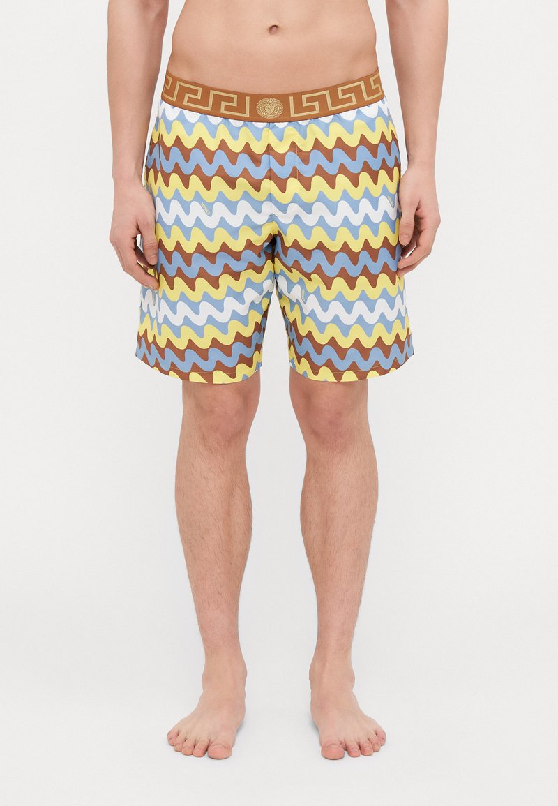 Simshorts i en vågig mönstring i blått, gult och brunt. Har ett brunt midjeband med grekisk nyckeldesign. Tillverkade av lätt material.