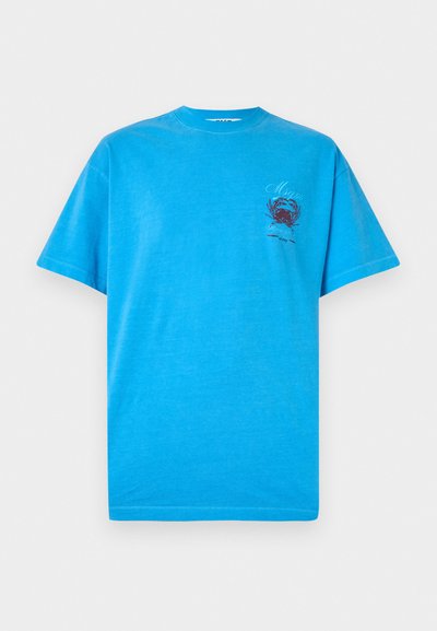 Hellblaues Baumwoll-T-Shirt mit einem grafischen Druck eines Krabbenmotivs in Dunkelrot auf der linken Brustseite. Rundhalsausschnitt und kurze Ärmel.