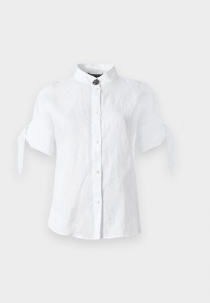 Blouse blanche à manches courtes avec col mandarin, fermeture boutonnée devant et détails noués aux manches sur un fond clair uni.