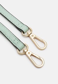 Mörkgrön konstläderrem med svart kant, med guldmetallsvängklipp i båda ändarna. Slät yta, inga synliga mönster.