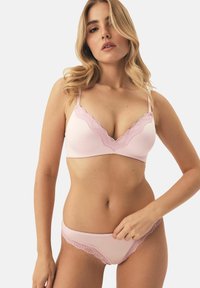 Różowy zestaw bielizny składający się z braletki z falbaniastym koronkowym wykończeniem i pasujących majtek. Miękka tkanina o bezszwowym wzorze.