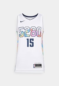 Bijela košarkaška majica s višebojnim cik-cak uzorkom sa strane, odvažnim mornarsko plavim brojem 5280 i 15, s Nike logotipom i NBA oznakom na rubu.