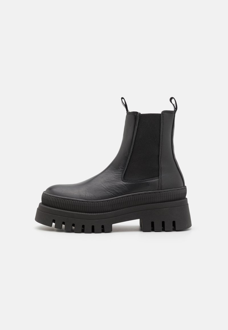 Black leather ankle boots with elastic side panels, pull tabs, chunky platform sole, and ridged detailing along the sole edge.