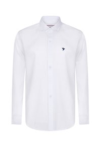 Camisa blanca de manga larga hecha de algodón, con cuello de botón y un logo de pájaro azul marino en el lado izquierdo del pecho. Textura suave.