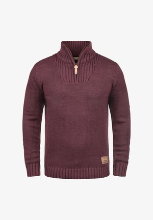 Bordový pletený svetr s vysokým límcem, polovičním zipem, žebrovanými manžetami a lemem. Obsahuje strukturované detaily a malou nášivku značky na boku.