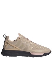 Beige athletic shoe with mesh upper, three side stripes, plastic accents, and a black sole. Features a rounded toe and textured design.