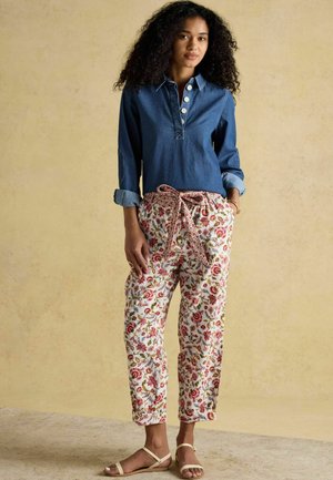 Cămașă din denim cu guler și închidere cu nasturi, asortată cu pantaloni albi cu imprimeu floral în nuanțe de roșu și verde și talie cu șnur ajustabil.