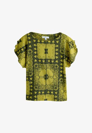 Korte mouw top met een groen en geel bladpatroon. De stof heeft een gestructureerde afwerking met decoratieve randmotieven en hartvormen.