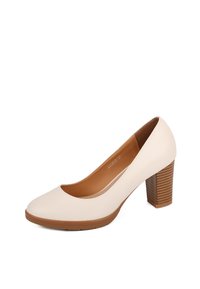 Pump color beige in pelle con tacco alto, punta arrotondata e tacco in legno texturizzato, con una finitura liscia e soletta imbottita.