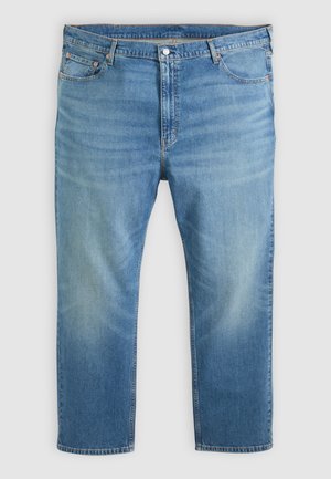 Lyseblå denimjeans med fem lommer, knaplukning og falmede detaljer på lårene og knæene, lagt fladt på en hvid baggrund.