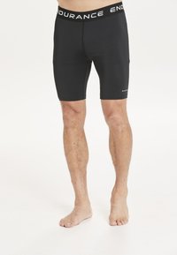 Svarta atletiska shorts med en åtsittande design, gjorda av stretchmaterial, med en hög midja och texten "ENDURANCE" i vitt.