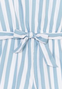 Niebiasto-biała tkanina w paski o miękkiej fakturze. Wzór zdobią pionowe linie, zwężona talia oraz związana kokarda na środku.