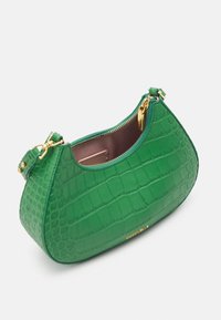 Zielona torebka ze skóry z wytłoczonym wzorem krokodyla, z złotym zamkiem błyskawicznym i dodatkami, z otwartym wierzchem i jasnobeżowym wnętrzem.