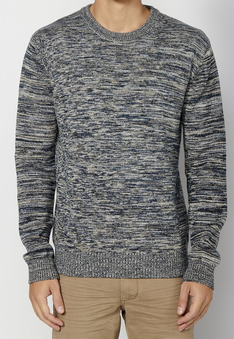 Pull en maille à motif chiné bleu et beige, doté d'un col rond et de manches longues, avec des poignets et un ourlet côtelés pour une finition texturée.