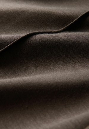 Donkerbruine stof met een gladde textuur en subtiele glans, plooien die diepte en variatie in licht en schaduw creëren.