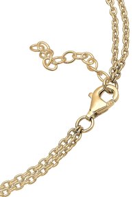 Chaîne en métal doré avec des maillons entrelacés et un fermoir en forme de homard. Présente une surface texturée et une petite extension de chaîne.