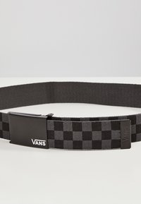 Svart och grå vävd bälte med ett rutmönster, med en svart metallspänne prydd med Vans-logotypen. Slät yta och justerbar längd.