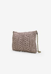 Borsa a tracolla intrecciata rosa con dettagli testurizzati, dotata di una catenina metallica decorativa e forma rettangolare.