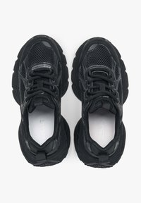 Czarne buty sportowe z siateczkowej cholewki i gumowej podeszwy. Cechy to okrągłe sznurowadła, wzmocniony czubek oraz teksturowane akcenty na korpusie.