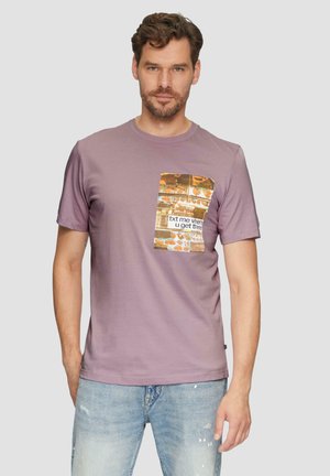 T-shirt en coton lilas à manches courtes avec un graphique rectangulaire représentant du texte et des images colorées de nourriture à l'avant. Coupe décontractée.